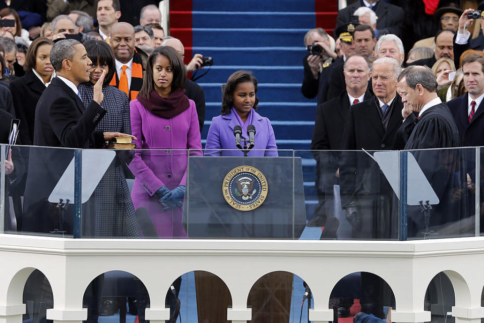 Barack Obama takes the presidential oath of office in 2009 with his family and Joe Biden standing next to him.