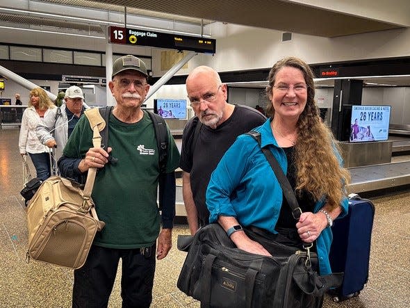 Larry Rudolph, left stands with the Castellinos, Angelo (left) and Shelley (right), at the airport in Washington state. They were there to be reunited with their cat, Butters, who had gone missing from their then-home in San Diego 12 years prior.