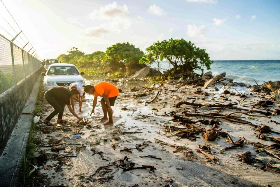 High-tide flooding and debris covering the road to the airport in the Marshall Islands capital Majuro in December 2021 (Photo by CHEWY LIN/AFP via Getty Images)