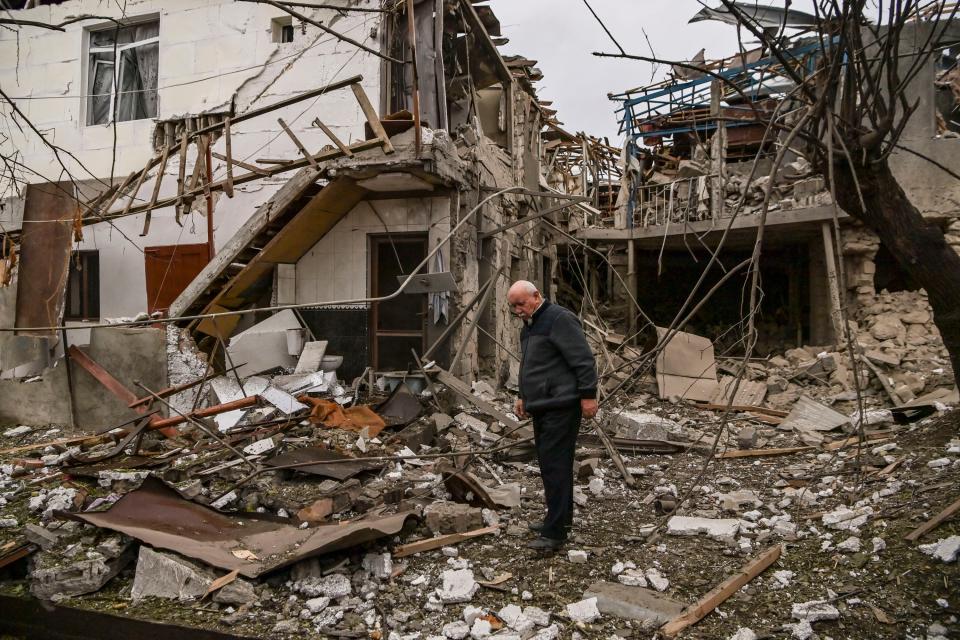 Man looks at rubble from destroyed home after Nagorno-Karabakh shelling