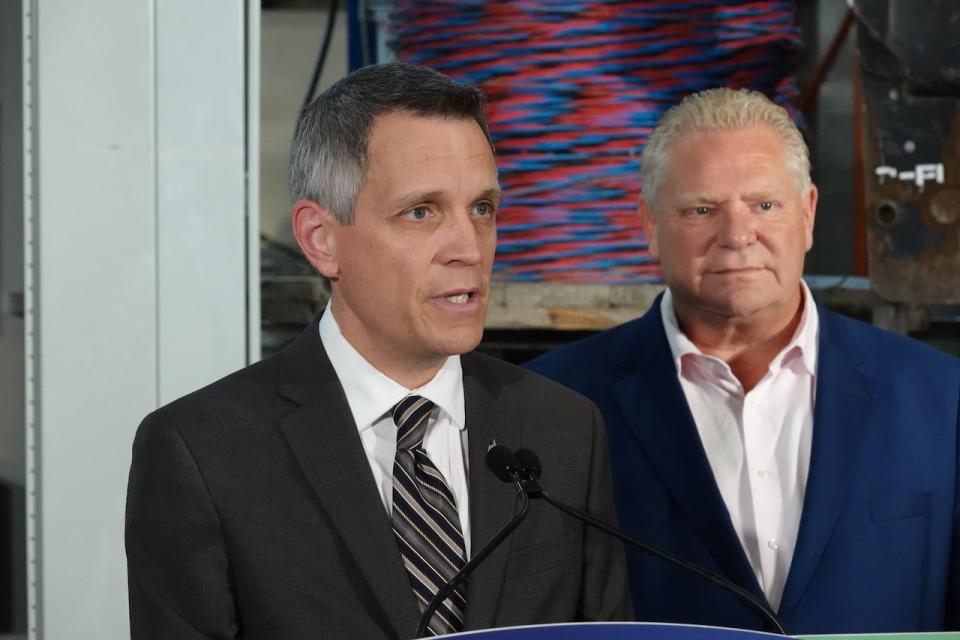 Ottawa Mayor Mark Sutcliffe, left, speaks this season as Ontario Premier Doug Ford listens behind him.  Sutcliffe said he spoke with Ford on the phone Monday following the announcement that responsibility for two major Toronto highways would be transferred to the province.  (Giacomo Panico/CBC - image credit)