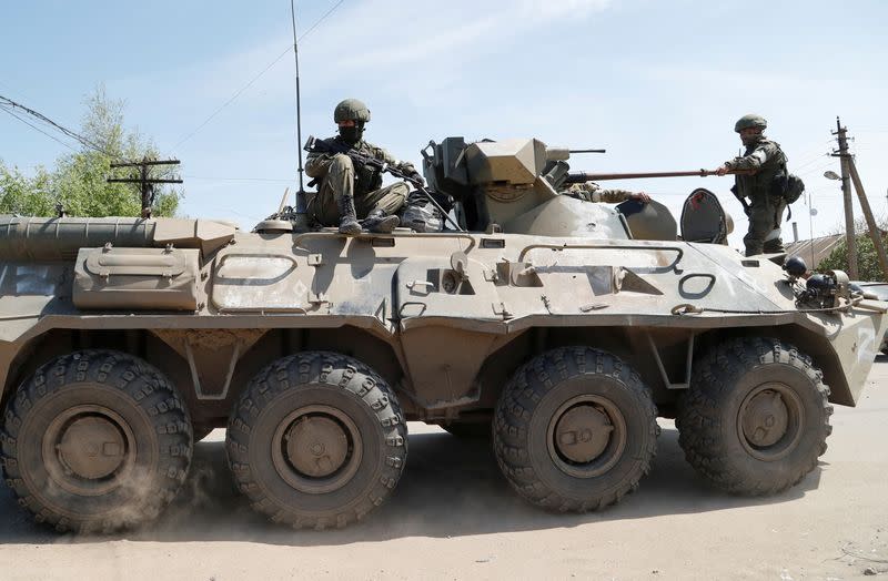 Service members of pro-Russian troops are seen atop of an armoured personnel carrier in Bezimenne