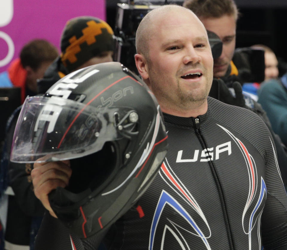 The pilot from the United States USA-1, Steven Holcomb celebrates his bronze medal win in the men's two-man bobsled competition at the 2014 Winter Olympics, Monday, Feb. 17, 2014, in Krasnaya Polyana, Russia. (AP Photo/Jae C. Hong)