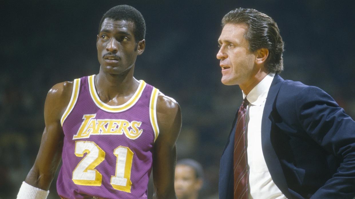 UNSPECIFIED - CIRCA 1985: Head Coach  Pat Riley of the Los Angeles Lakers talks with his player Michael Cooper #21 during an NBA basketball game circa 1985. Riley coached the Lakers from 1981-1990. (Photo by Focus on Sport/Getty Images)