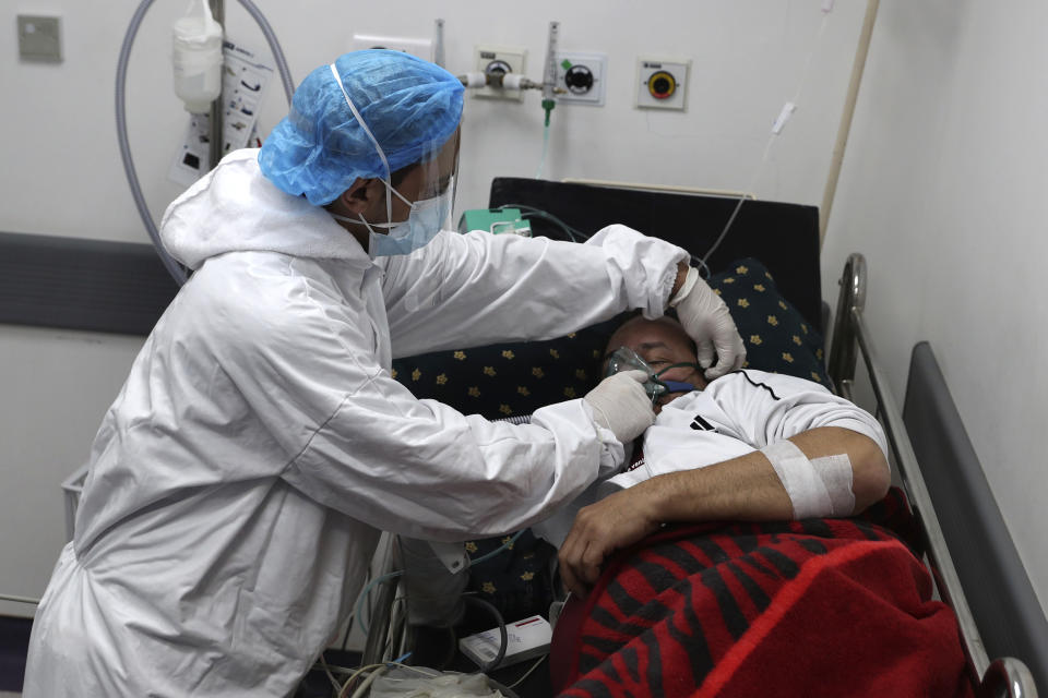 A medical staffer assists with oxygen supply to a COVID-19 patient at the intensive care unit of the Rafik Hariri University Hospital in Beirut, Lebanon, Friday, Jan. 22, 2021. Hospitals in Lebanon are reaching full capacity amid a dramatic surge in coronavirus cases across the crisis-hit Mediterranean nation even amid strict lockdown. (AP Photo/Bilal Hussein)