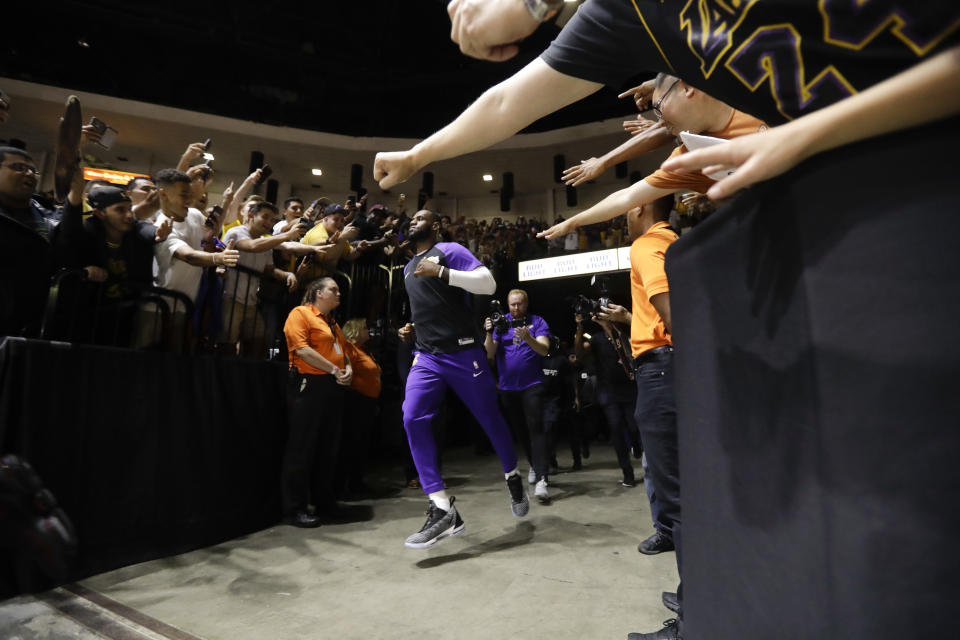 Los Angeles Lakers forward LeBron James runs past fans on his way to the court before an NBA preseason basketball game against the Denver Nuggets Sunday, Sept. 30, 2018, in San Diego. (AP Photo/Gregory Bull)