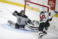 Los Angeles Kings goalie Jonathan Quick, left, stretches to block a shot by Minnesota Wild center Marcus Johansson during the first period of an NHL hockey game in Los Angeles, Saturday, Jan. 16, 2021. (AP Photo/Kelvin Kuo)