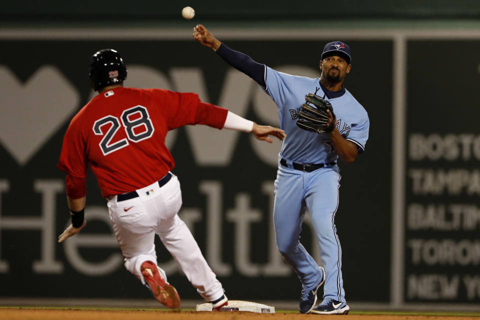 Toronto Blue Jays' Marcus Semien throws over Boston Red Sox's J.D. Martinez but can't get a double play on a ball hit by Xander Bogaerts during the fifth inning of a baseball game Tuesday, April 20, 2021, at Fenway Park in Boston. (AP Photo/Winslow Townson)