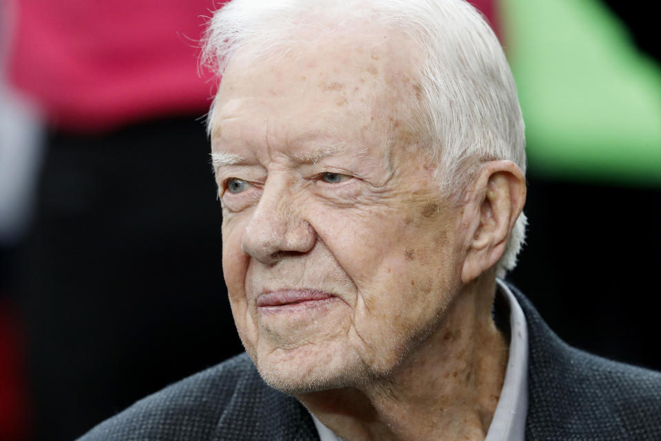 CORRECTS DATE OF CARTER CENTER'S STATEMENT TO FEB. 18, NOT FEB. 19 - FILE - Former President Jimmy Carter sits on the Atlanta Falcons bench before the first half of an NFL football game between the Falcons and the San Diego Chargers, Sunday, Oct. 23, 2016, in Atlanta. Carter, at age 98 the longest-lived American president, has had a recent series of short hospital stays. The Carter Center said in a statement Saturday, Feb. 18, 2023, that the 39th president has now “decided to spend his remaining time at home with his family and receive hospice care instead of additional medical intervention.” (AP Photo/John Bazemore, File)