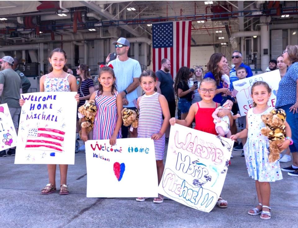 Happy and expectant little girls await their dad’s return from deployment on Labor Day at Quonset Air National Guard Base in North Kingstown.