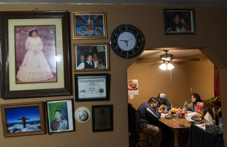 Mario Valdez, 62, center, eats dinner with his wife, Reyna, 52, right, and their son Axel, 18, at their home in Central Falls, R.I., Thursday, Feb. 18, 2021. The three were fully vaccinated for COVID-19 this month as part of a special effort to inoculate every resident of Central Falls, the Rhode Island community hit hardest by the pandemic. (AP Photo/David Goldman)