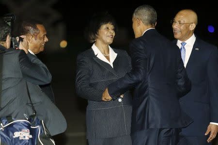 U.S. President Barack Obama (2nd R) is greeted by Jamaica's Prime Minister Portia Simpson Miller (C) as he arrives aboard Air Force One at Norman Manley International Airport in Kingston, Jamaica April 8, 2015. REUTERS/Jonathan Ernst