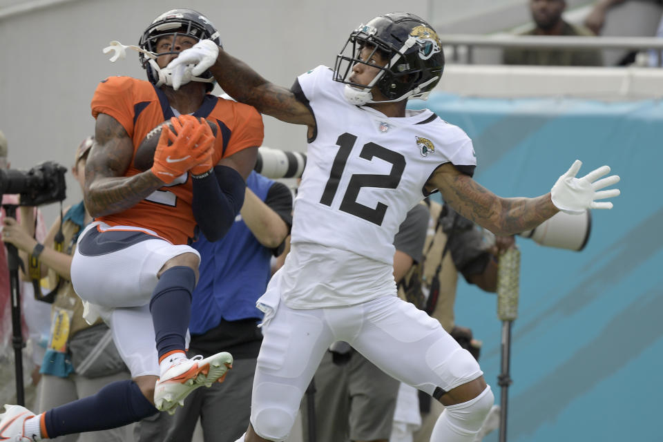 Denver Broncos cornerback Pat Surtain II, left, intercepts a pass intended for Jacksonville Jaguars wide receiver Tyron Johnson (12) during the second half of an NFL football game, Sunday, Sept. 19, 2021, in Jacksonville, Fla. (AP Photo/Phelan M. Ebenhack)