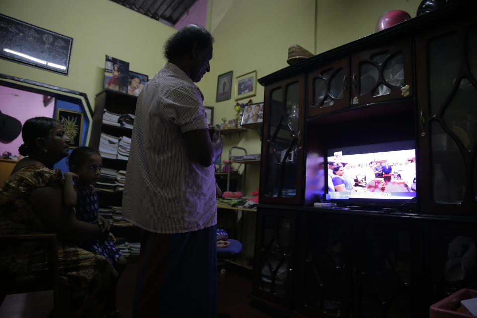 Sri Lankan family follow breaking news in television in Colombo, Sri Lanka, Friday, Oct. 26, 2018. Sri Lankan President Maithripala Sirisena has sacked the country's prime minister and replaced him with a former strongman, state television said Friday. (AP Photo/Eranga Jayawardena)