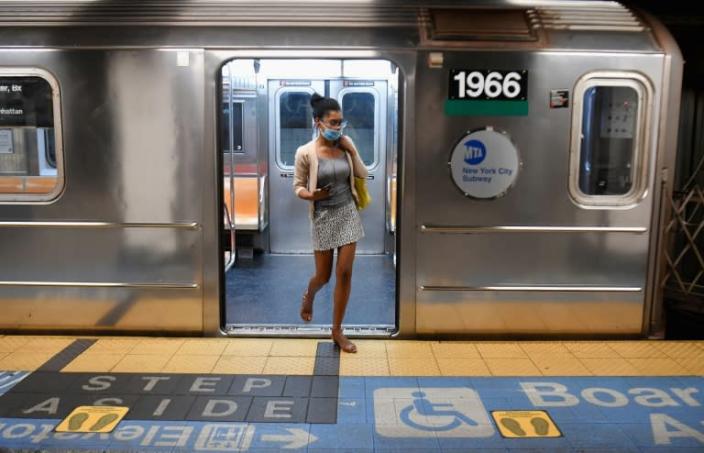 Some people don't have the economic luxury of being able to stay home for prolonged periods - here a passenger exiting a nearly empty New York City commuter train (AFP Photo/Angela Weiss)