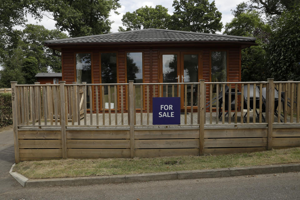 A holiday lodge stands with a for sale sign outside, at the Edgeley Holiday Park in Farley Green, near Guildford, south west of London, Wednesday, July 22, 2020. With all schools now closed, Friday would normally be the busiest departure day of the year for London’s Gatwick Airport with families heading off to the sun-soaked beaches in southern Europe. Not this year as the coronavirus pandemic has meant many have opted against making their annual summer migration to countries like Spain and Greece. Gatwick would in any normal year be expecting to fly some 85,000 holidaymakers on Friday alone. It expects less than 10,000 passenger departures on Friday. (AP Photo/Matt Dunham)