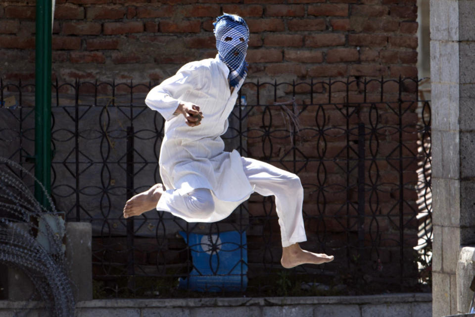 <p>A Kashmiri-masked Muslim protester jumps in the air to avoid stones thrown at him by Indian police during a protest in Srinagar, Indian-controlled Kashmir, April 29, 2016. Government forces fired tear gas and pellet guns to stop rock-throwing Kashmiri youths after Friday prayers. The demonstrators were responding to a protest call by anti-India separatist leaders against, what they said, government’s failure to arrest the troops involved in the recent killing of five civilians following an alleged molestation of a teenage girl student by an Indian soldier.<i> (Dar Yasin/AP)</i></p>