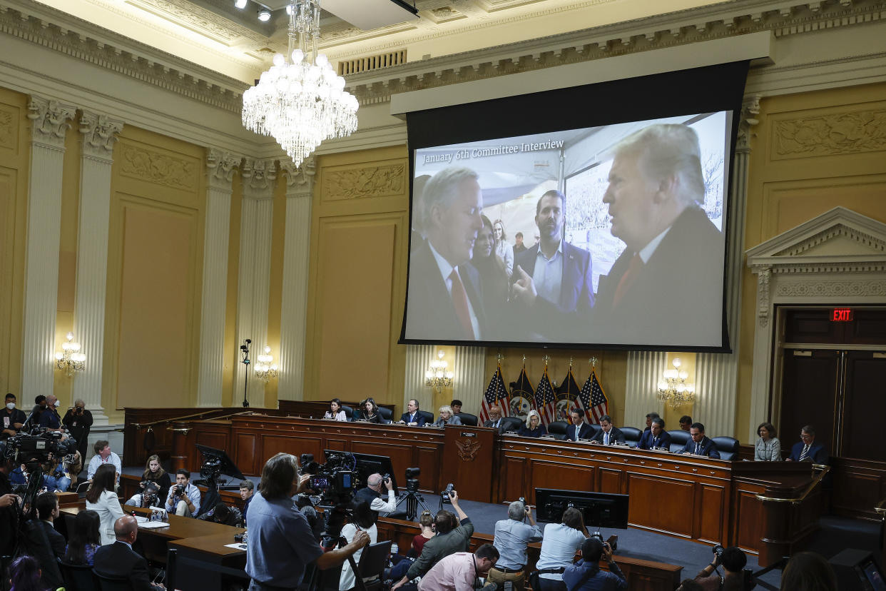 Video of former President Donald Trump talking to his chief of staff, Mark Meadows, left,  plays at the hearing, with Donald Trump Jr., center, behind them. (Anna Moneymaker/Pool via AP)