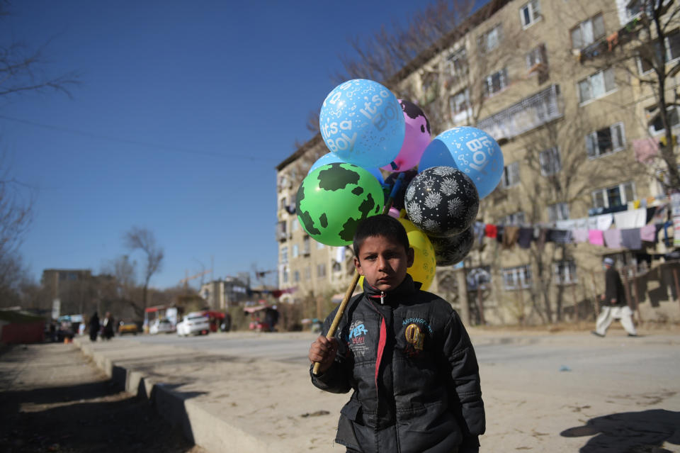 <p>An Afghan child who works as a balloon vendor waits for customers in Kabul on December 6, 2016. (Photo: Shah Marai/ AFP/Getty Images) </p>