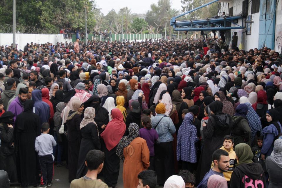 Palestinians gather to receive aid outside a UN warehouse in Gaza City, northern Gaza (Reuters)