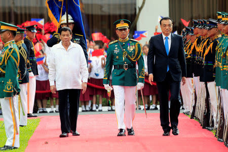 Philippine President Rodrigo Duterte and Chinese Premier Li Keqiang review honor guards upon arrival during Li Keqiang's visit, at the Malacanang presidential palace in Manila, Philippines November 15, 2017. REUTERS/Romeo Ranoco