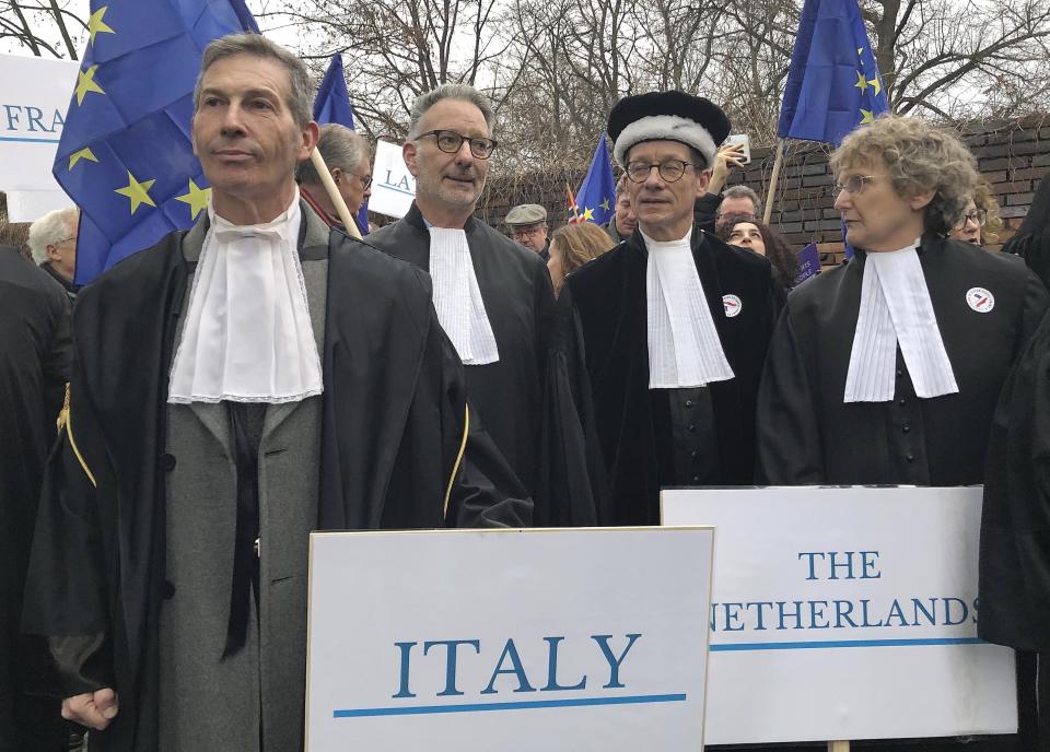 Judges from Italy, the Netherlands and elsewhere in Europe, many wearing their professional gowns, take part in a march in support of judicial independence in Warsaw, Poland, on Saturday Jan. 11, 2020. The judges marched silently in Warsaw in a show of solidarity with Polish peers who are protesting a bill that would allow the government to fire judges who issue rulings officials don't like. (AP Photo/Vanessa Gera)