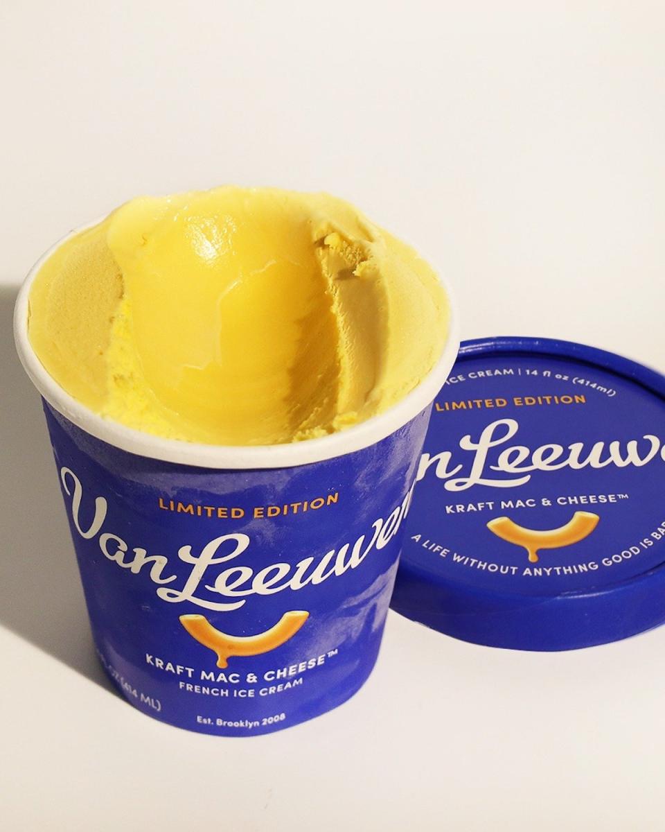 An open pint of Van Leeuwen Kraft Macaroni and Cheese ice cream next to its blue lied