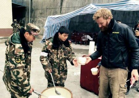 Rescuers scoop porridge for a foreign tourist (R) at a temporary shelter near the China-Nepal border, after a 7.9 magnitude earthquake hit Nepal, in Zhangmu township of Xigaze Prefecture, Tibet Autonomous Region, China, April 26, 2015. REUTERS/Stringer