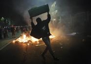 A demonstrator holds up a wastepaper bin during a protest against the 2014 World Cup, in Sao Paulo May, 15 2014. Road blocks and marches hit Brazilian cities on Thursday as disparate groups criticized spending on the upcoming World Cup soccer tournament and sought to revive a call for better public services that swept the country last June. REUTERS/Nacho Doce (BRAZIL - Tags: SPORT SOCCER CIVIL UNREST WORLD CUP TPX IMAGES OF THE DAY)