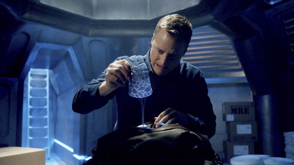 This image released by SYFY shows Alan Tudyk in a scene from "Resident Alien." In the series, Tudyk's character was tasked with destroying all Earthlings, and he takes the life and identity of Dr. Harry Vanderspeigle to appear human, but awkwardly, as he pursues his mission. Instead, he begins to value his intended victims. (SYFY via AP)