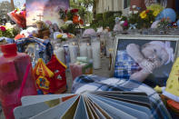 Photos, candles, flowers and balloons are placed as a memorial for three children who were killed at the Royal Villa apartments complex in the Reseda section of Los Angeles, on Monday, April 12, 2021. Authorities have identified 3-year-old Joanna Denton Carrillo, her 2-year-old brother, Terry, and 6-month-old sister, Sierra, as the three young children who were killed over the weekend. Their mother is the suspect in their deaths and was being held in a central California jail. (AP Photo/Richard Vogel)