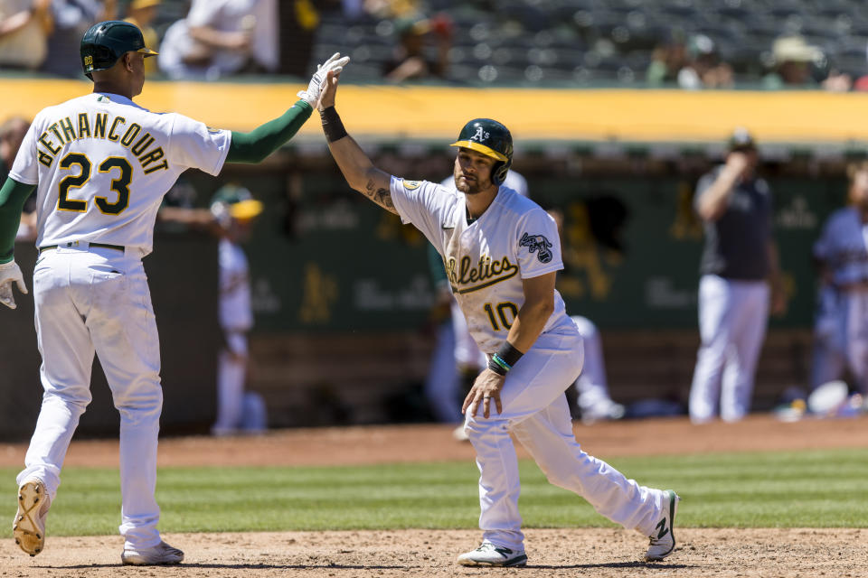 Oakland Athletics' Chad Pinder (10) celebrates with Christian Bethancourt (23) after Pinder scored against the Houston Astros during the seventh inning of a baseball game in Oakland, Calif., Wednesday, June 1, 2022. (AP Photo/John Hefti)