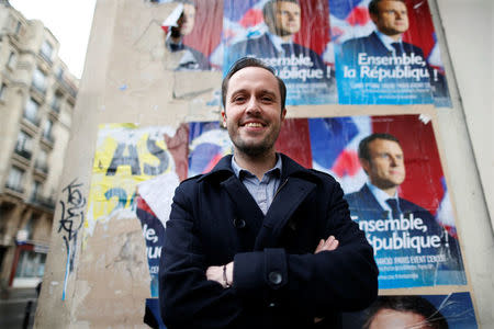 Christophe Brunelle, a teacher and campaigner for Emmanuel Macron, candidate for 2017 presidential election and head of the political movement En Marche !, or Onwards !, poses in front of campaign posters in Paris, France, May 3, 2017. REUTERS/Charles Platiau