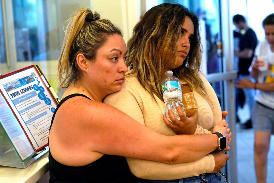Cousins Andrea and Nellie Gonzalez wait for news at a family reunification center, after a wing of a 12-story beachfront condo building collapsed, Thursday, June 24, 2021, in the Surfside area of Miami. They are vacationing from Wisconsin and had to be evacuated from a nearby building.