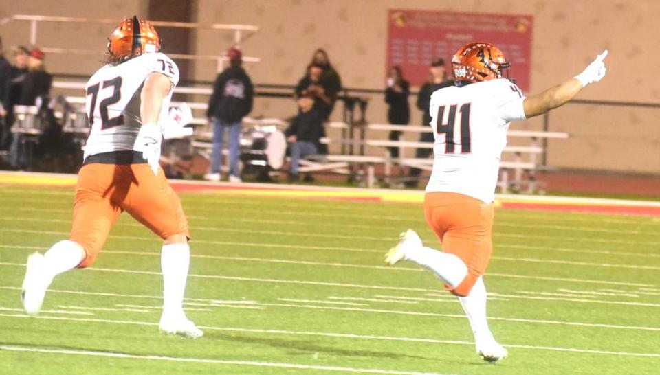 Merced High School linebacker Anthony Mendoza (41) raises his hand in celebration as he returns an interception 60 yards for a touchdown during the second quarter of a playoff game against Oakdale on Friday, Nov. 11, 2023.