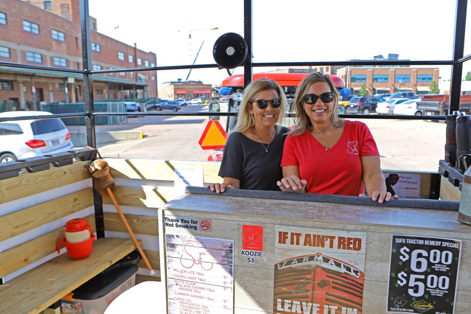 Tanya Harder (left) and Ava Ohnstad, along with their husbands, started SuFu Tractor. SuFu Tractor is a party trailer pulled by a tractor that features a bar and takes groups of people around downtown Sioux Falls.