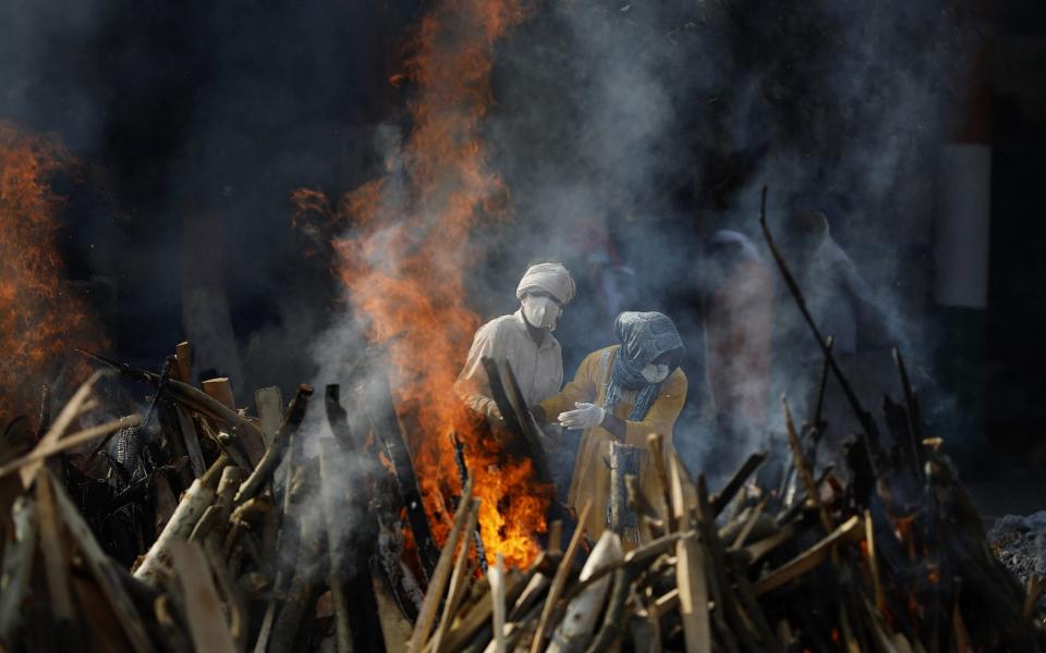 Relatives of coronavirus victims perform cremation, at a crematorium in New Delhi, - Anadolu