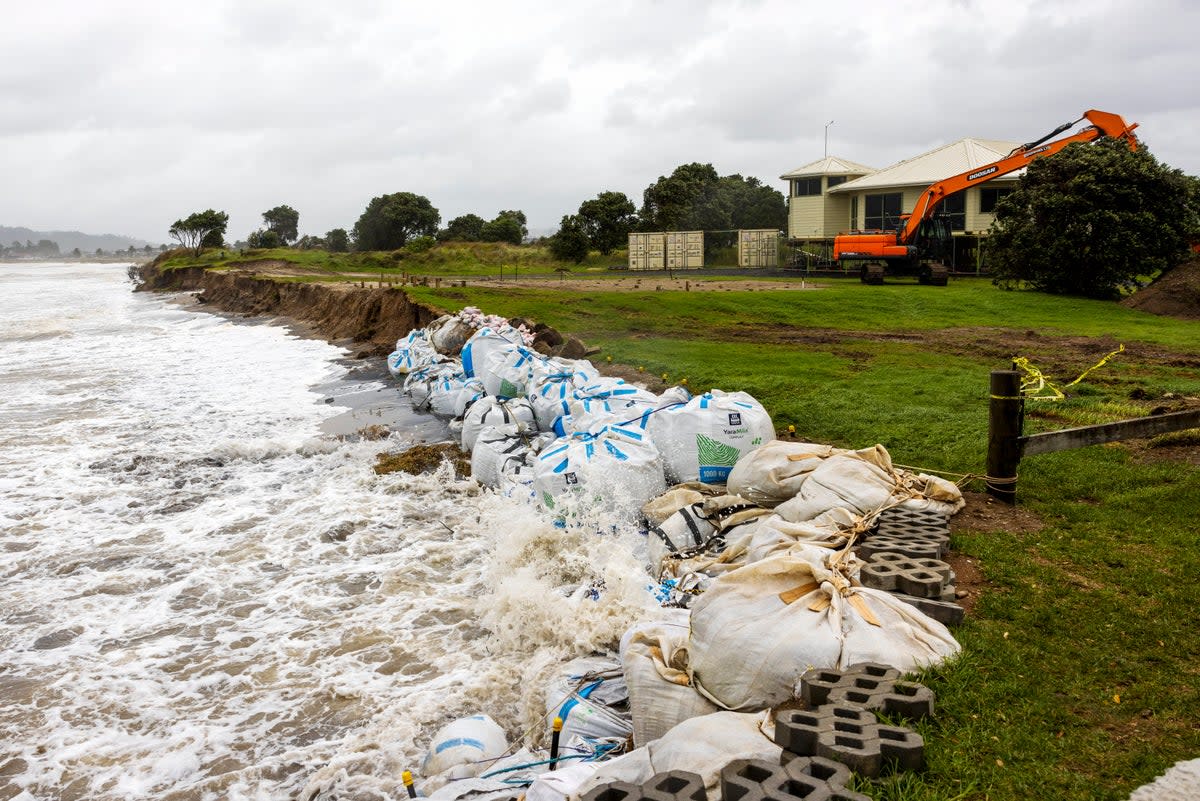 Sand bags are placed along the coastline as Cyclone Gabrielle buffets the Coromandel, south of Auckland, Sunday (New Zealand Herald)