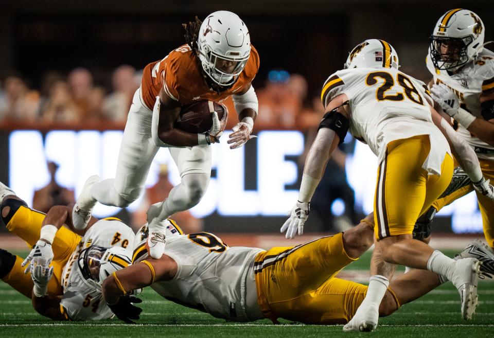 Texas running back Jonathon Brooks leaps over a Wyoming lineman for first-down yardage during the first quarter Saturday night. Brooks finished with a career-high 164 yards.