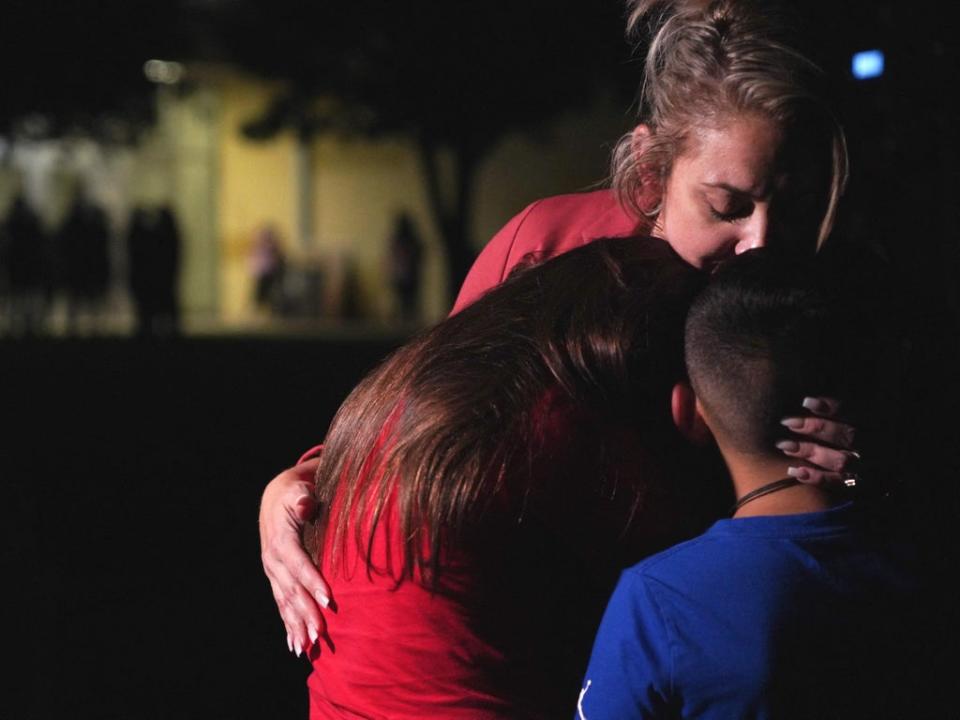 Families hug outside a centre where grief counseling will be offered in Uvalde following a school shooting (AFP via Getty Images)