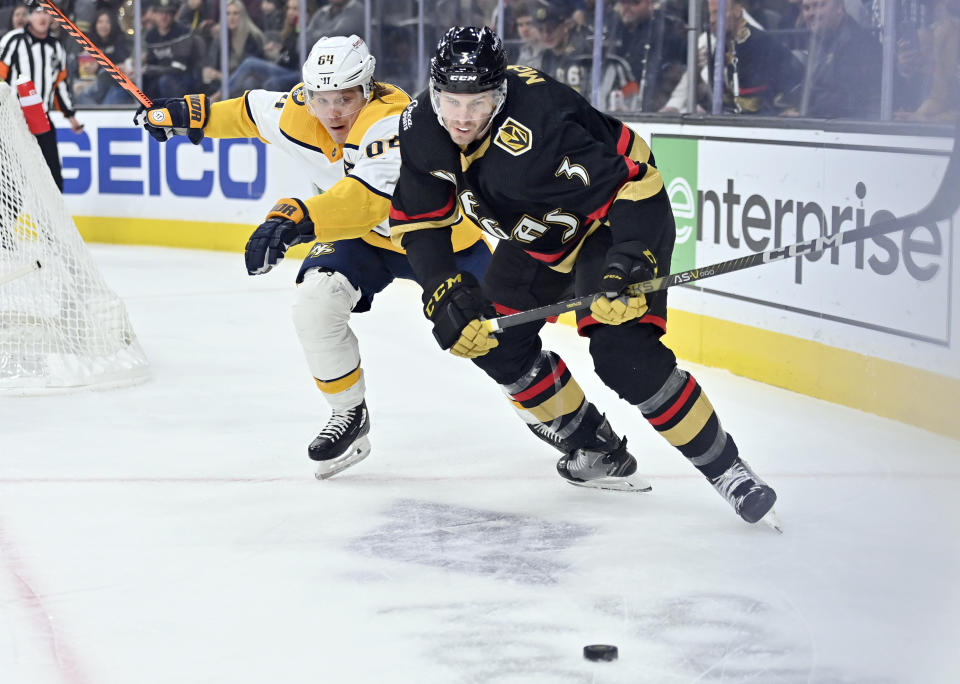 Nashville Predators center Mikael Granlund (64) and Vegas Golden Knights defenseman Brayden McNabb (3) skate after the puck during the first period of an NHL hockey game Saturday, Dec. 31, 2022, in Las Vegas. (AP Photo/David Becker)