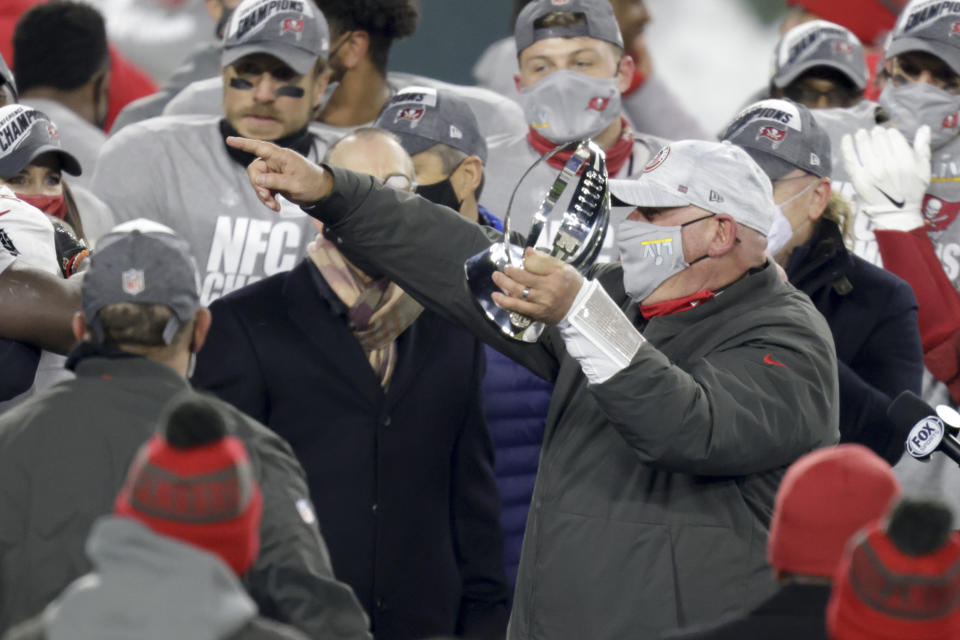 Tampa Bay Buccaneers head coach Bruce Arians holds the championship trophy after winning the NFC championship NFL football game against the Green Bay Packers in Green Bay, Wis., Sunday, Jan. 24, 2021. The Buccaneers defeated the Packers 31-26 to advance to the Super Bowl. (AP Photo/Matt Ludtke)