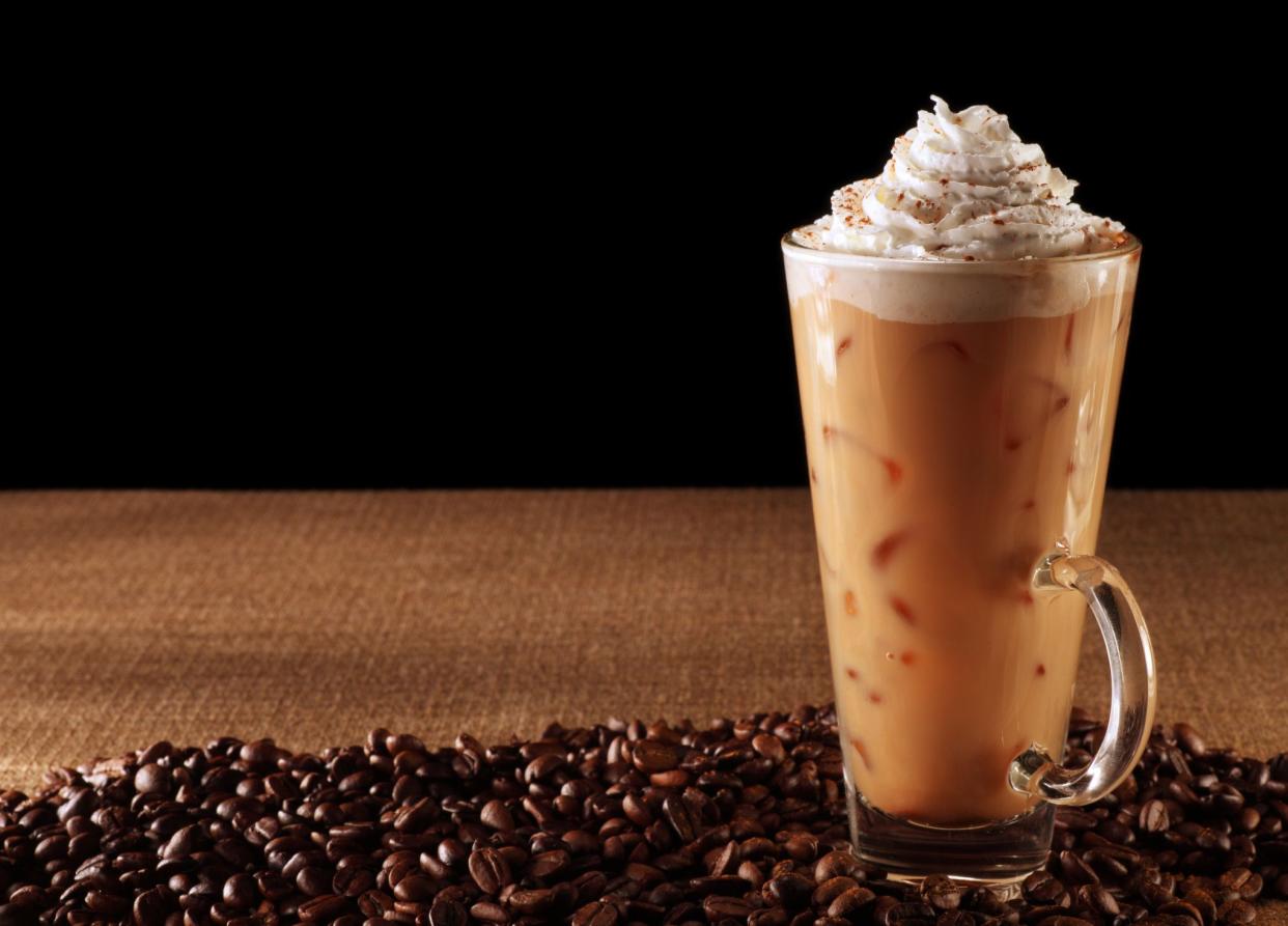 This is a photograph of an iced coffee with whipped cream. There is a lot of space for copy in the black.