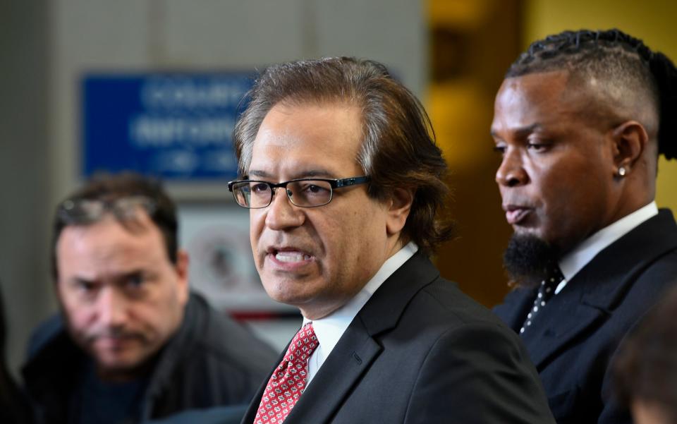 Lawyer Doug Anton,  left, and publicist Darrell Johnson, right, speaks to the media after R. Kelly's latest hearing in his criminal sex-abuse case.