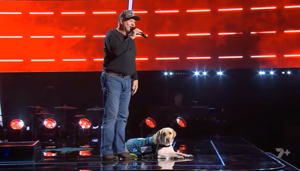 Chris Hodder performing on The Voice with his support dog Bella. 