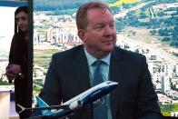 Boeing Commercial Airplanes president and CEO Stanley A. Deal sits in front of a model of a Boeing 737 Max at a news conference during the Dubai Airshow in Dubai, United Arab Emirates, Monday, Nov. 18, 2019. The Turkish-German airline SunExpress announced Monday it will be buying 10 of the troubled Boeing 737-8 Max jets, grounded globally after crashes, in a deal worth $1.2 billion. (AP Photo/Jon Gambrell)