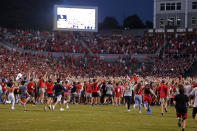 North Carolina State fans run on to the field after the Wolfpack defeated Clemson 27-21 in double overtime at an NCAA college football game in Raleigh, N.C., Saturday, Sept. 25, 2021. (AP Photo/Karl B DeBlaker)