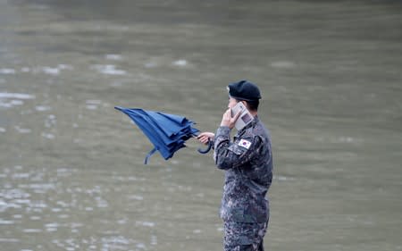 Military official from the South Korean Embassy is seen on his mobile phone at the Danube river bank in Budapest