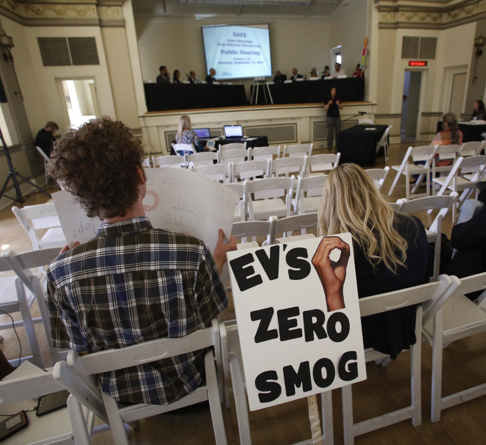 Benjamin Tuggy, left, listens to speakers during the first of three public hearings on the Trump administration's proposal to roll back car-mileage standards in a region with some of the nation's worst air pollution Monday, Sept. 24, 2018 in Fresno, Calif. The day-long session by the U.S. Environmental Protection Agency and National Highway Traffic Safety Administration is a means to gather public comment concerning the mileage plan, which would freeze U.S. mileage standards at levels mandated by the Obama administration for 2020, instead of letting them rise to 36 miles per gallon by 2025. (AP Photo/Gary Kazanjian)