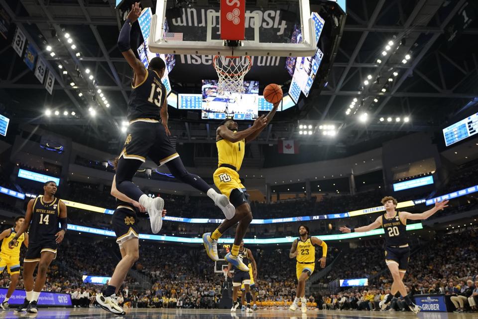 Marquette's Kam Jones shoots past Notre Dame's Tae Davis during the first half of an NCAA college basketball game Saturday, Dec. 9, 2023, in Milwaukee. (AP Photo/Morry Gash)